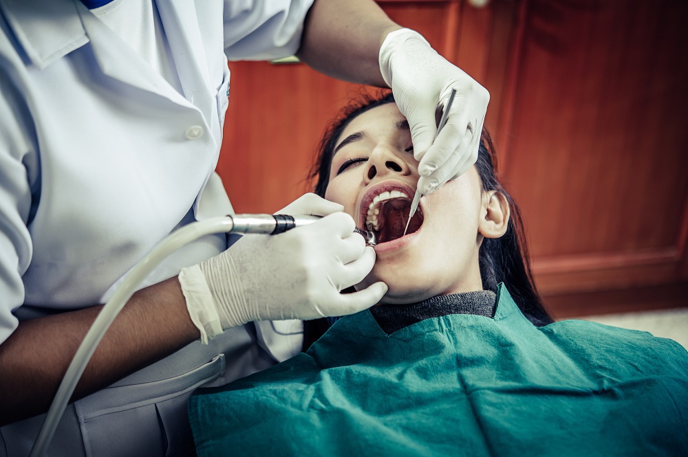 woman taking root canal treatment from our dentist